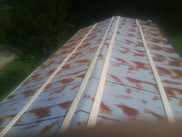 Rusted metal roof panels with new wood purlins before replacement — Storm Damage Roof Repair in Wendell by Roofing Brothers