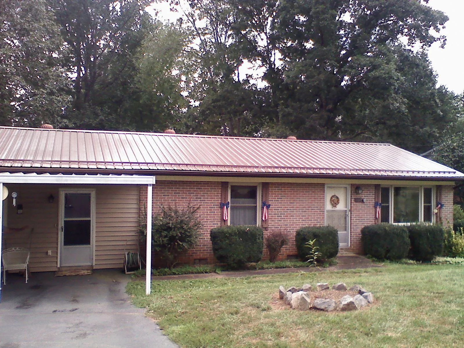 Bronze metal roof and carport on a brick ranch home — Roof Repair work by our crew in Wendell